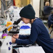 Evie Fachon examines water samples under a microscope. Photo by Lindsey Leigh Graham/NOAA.